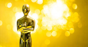 Golden statuette on shiny yellow background.
